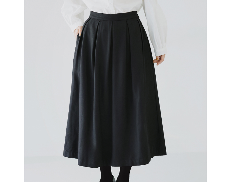 タック入りのフレアスカート。歩くたびに揺れる上品なシルエット。