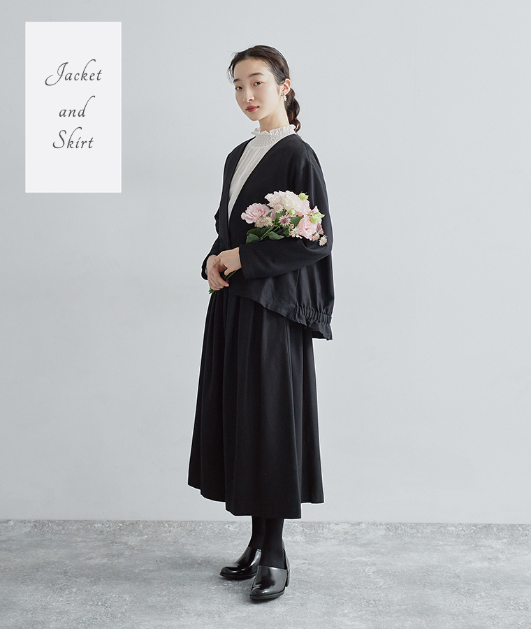 ノーカラージャケットとタックフレアスカートのオケージョンコーデ。白ブラウスで上品にまとめたブラックスタイル。