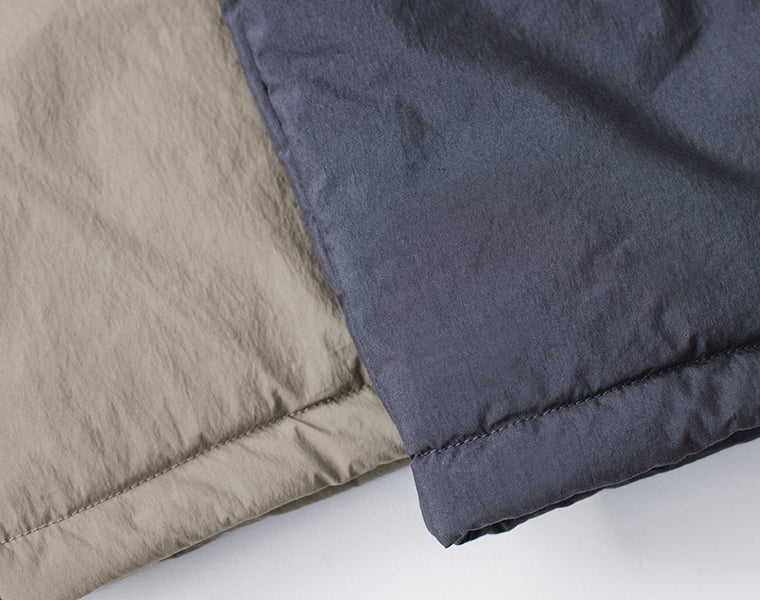 コットンナイロン中綿コクーンコートのネイビーとカーキベージュの裾部分を並べて撮影した写真