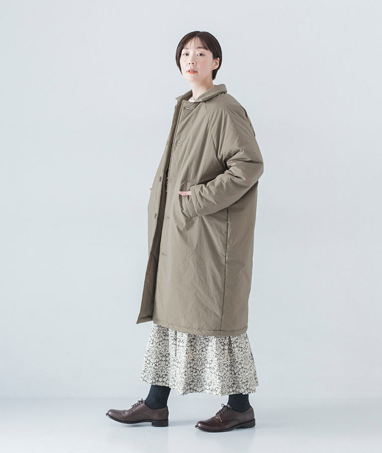 花柄ワンピースの上にコットンナイロン中綿コクーンコート カーキベージュを着用したモデルの全身横向き