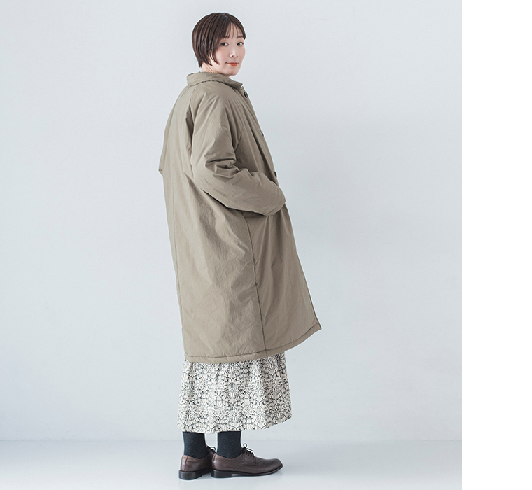 花柄ワンピースの上にコットンナイロン中綿コクーンコート カーキベージュを着用したモデルの全身横向き後ろ姿