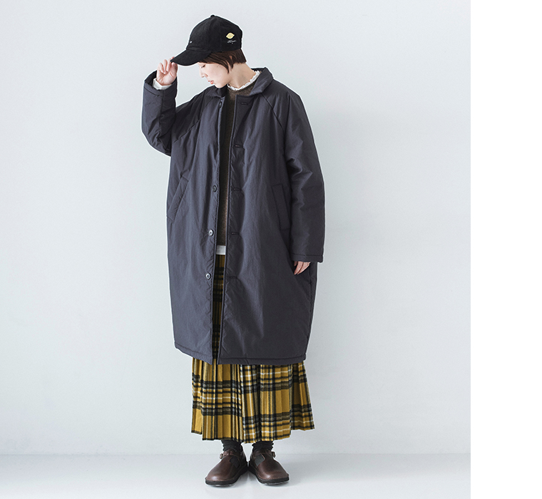 イエローチェックスカートとコットンナイロン中綿コクーンコート ネイビーを着用したモデルの全身正面やや下向き