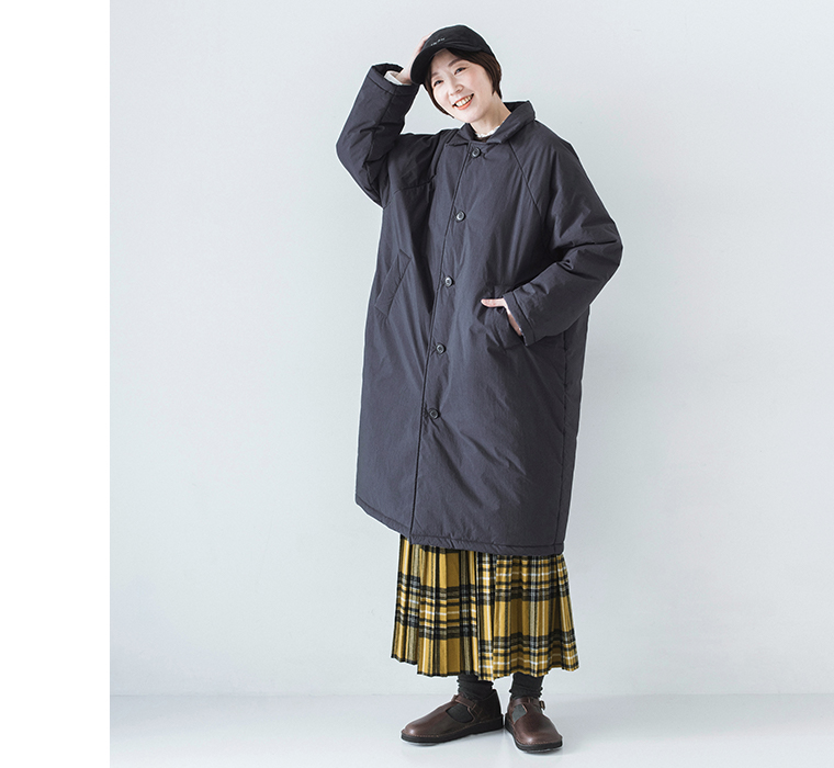 イエローチェックスカートとコットンナイロン中綿コクーンコート ネイビーを着用したモデルの全身正面