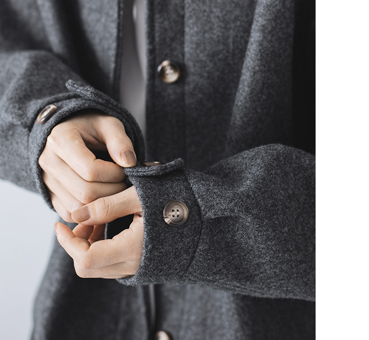 リブブルゾン（チャコール）の袖口ボタンを留める手元のディテール