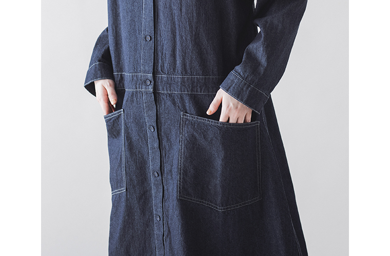 大きめのフロントポケットとグレーのステッチが映えるデニムコートワンピースのディテール