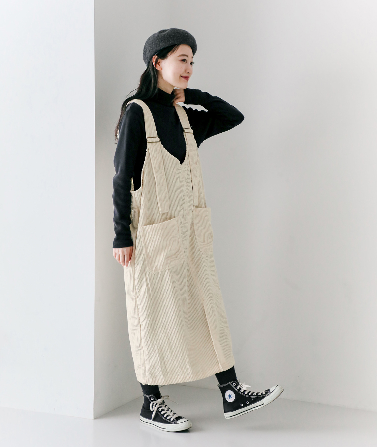 太いコーデュロイジャンパースカート アイボリーを着用したモデルの全身横向き