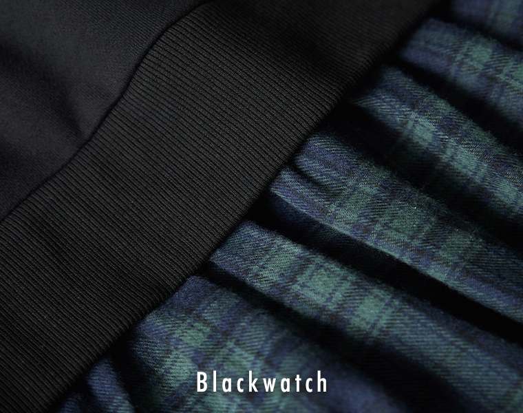 ブラックウォッチ柄のスカート生地と裏毛トップス部分の切り替えディテールを写したアップ画像。ギャザーの入った柔らかな風合いが分かる商品写真。