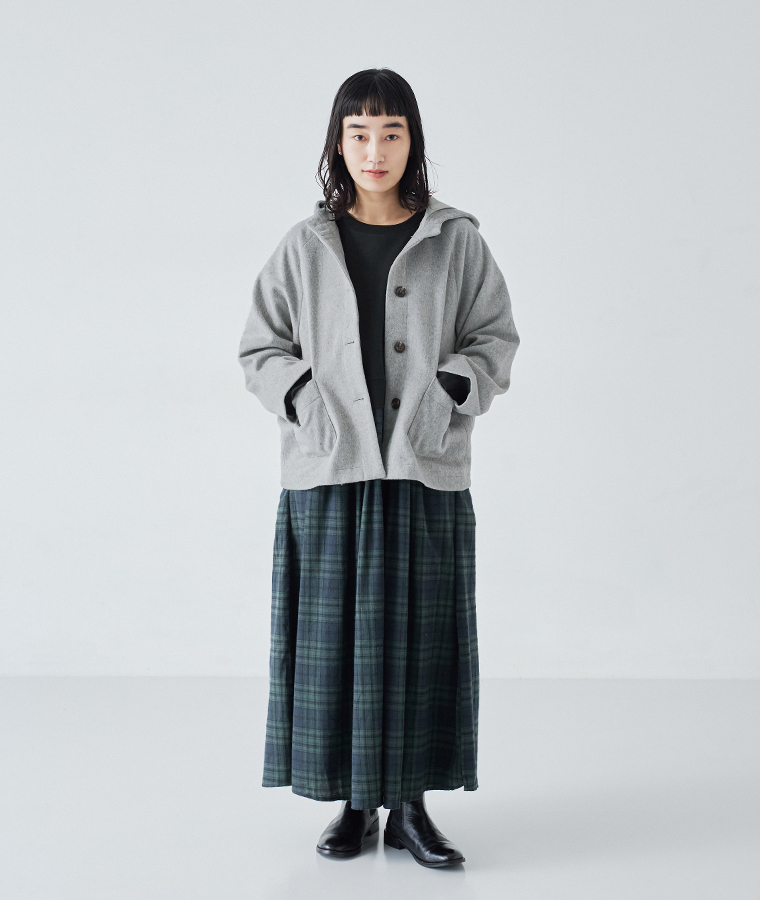 ブラックウォッチ柄の別注 裏毛切替ワンピースに、グレーのショートコートを羽織ったコーディネート写真。