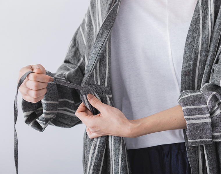 リネンコットンオリジナルランダムストライプドレスのウエストの内紐を結ぶ手元のディテール