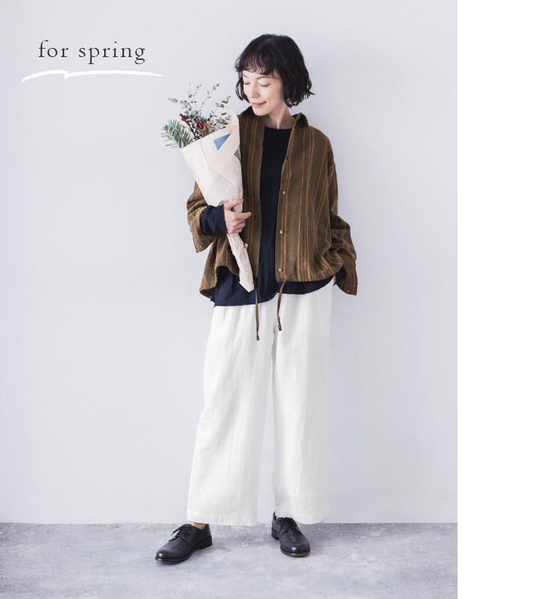 リネンコットンオリジナルランダムストライプシャツを白のパンツに合わせて花束を持った春のコーディネート
