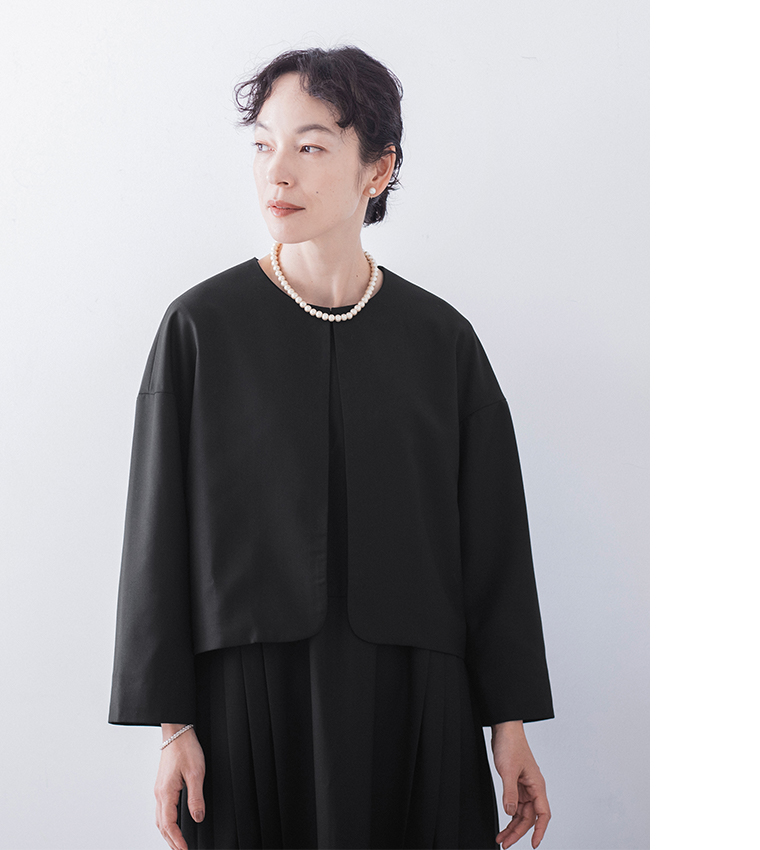 ブラックのジャケットの上半身アップ（パールネックレスとイヤリングのアクセント）