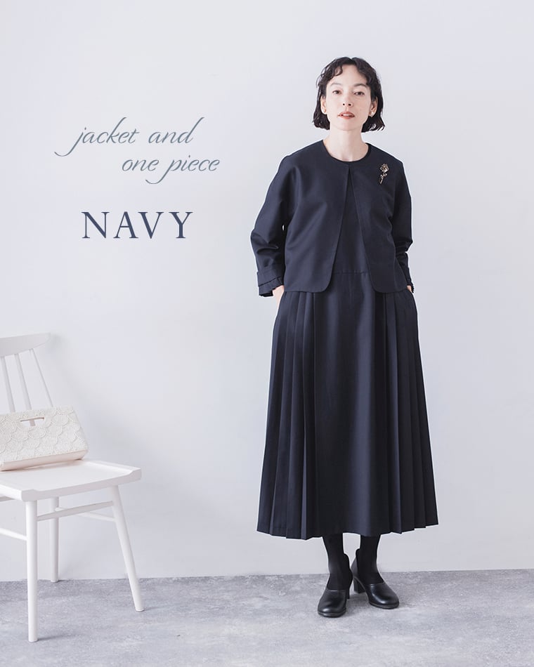 ネイビーのジャケットとワンピースの正面（クラッチバッグ付き）