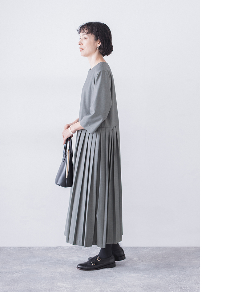グレーのプリーツワンピースの横姿（バッグとシューズのコーディネート）