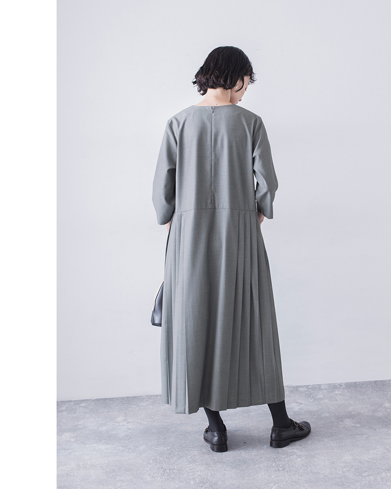 グレーのプリーツワンピースのバックスタイル（ウエスト切替とボタンディテール）