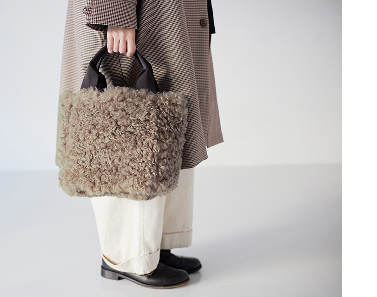  フェイクファーチェック柄リバーシブルトートを手に持ったサイズ感イメージ