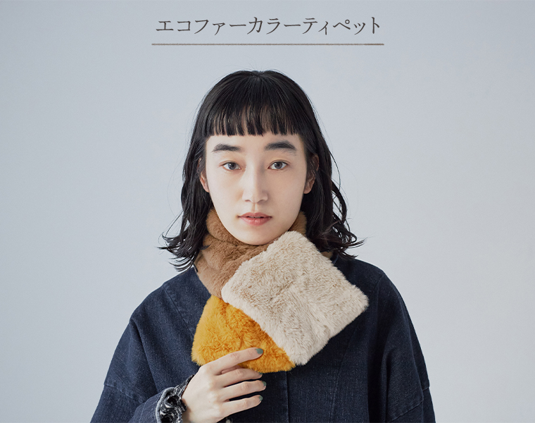 キュアスタイルのエコファー カラーティペットを首元に着用した女性モデルの上半身