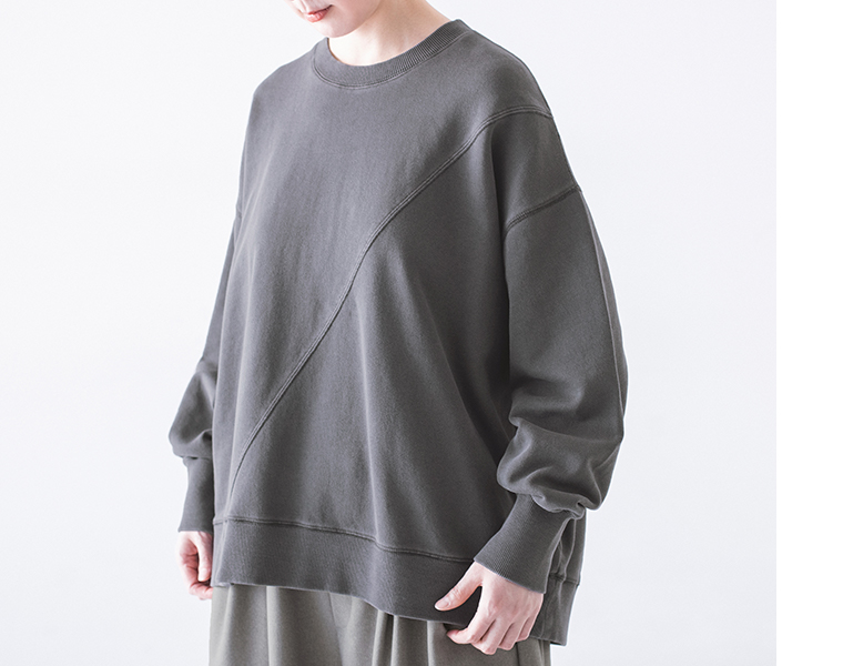 ピグメント裏毛斜め切り替えプルオーバー チャコールを着用したモデルの上半身斜め
