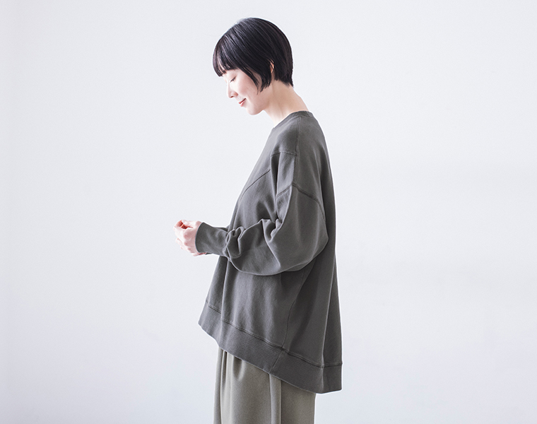 ピグメント裏毛斜め切り替えプルオーバー チャコールを着用したモデルの横向き上半身