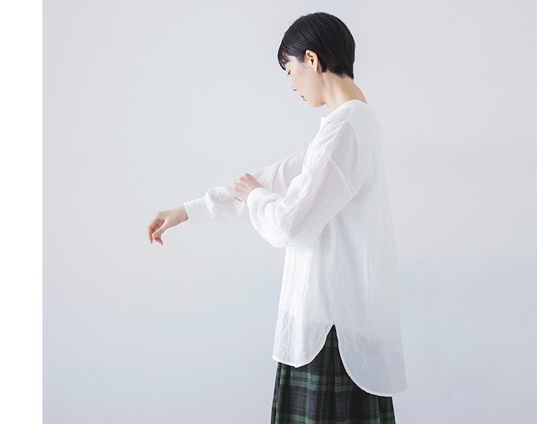 リブ長袖切替プルオーバー ホワイトを着用したモデルの横向き全身でチェック柄スカートと合わせたコーディネート