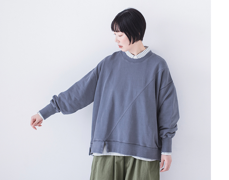 ピグメント裏毛斜め切り替えプルオーバー ブルーを着用したモデルの上半身正面でシャツをレイヤードしカーキのワイドパンツを合わせたコーディネート