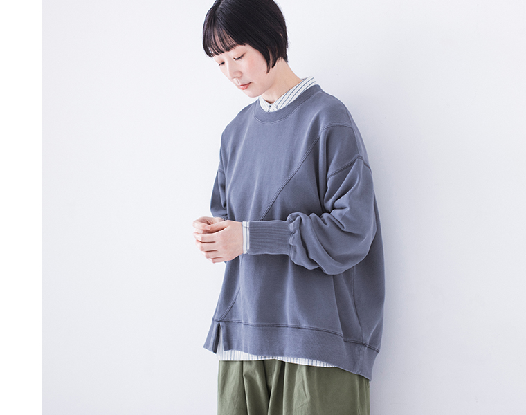 ピグメント裏毛斜め切り替えプルオーバー ブルーを着用したモデルの上半身斜め向きでシャツをレイヤードしたコーディネート