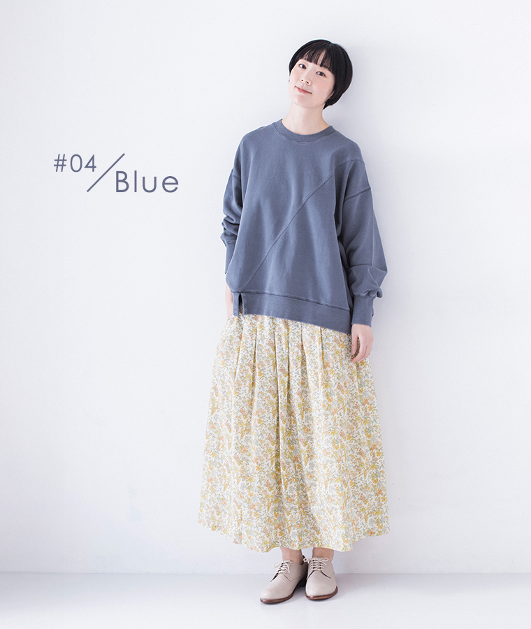 ピグメント裏毛斜め切り替えプルオーバー ブルーを着用したモデルの全身正面で小花柄スカートとベージュのシューズを合わせたコーディネート