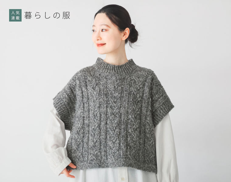 グレーのMIXメランジケーブルニットベストを白シャツワンピースの上に重ねて着用しているコーディネート