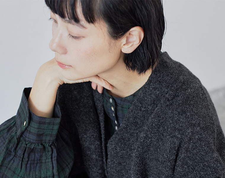 やわらかな風合いのチャコールロングベスト。首元をすっきり見せるデザイン