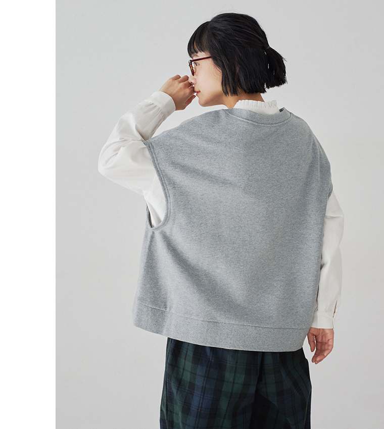 トップグレーの裏毛ベストとチェックパンツの後ろ姿