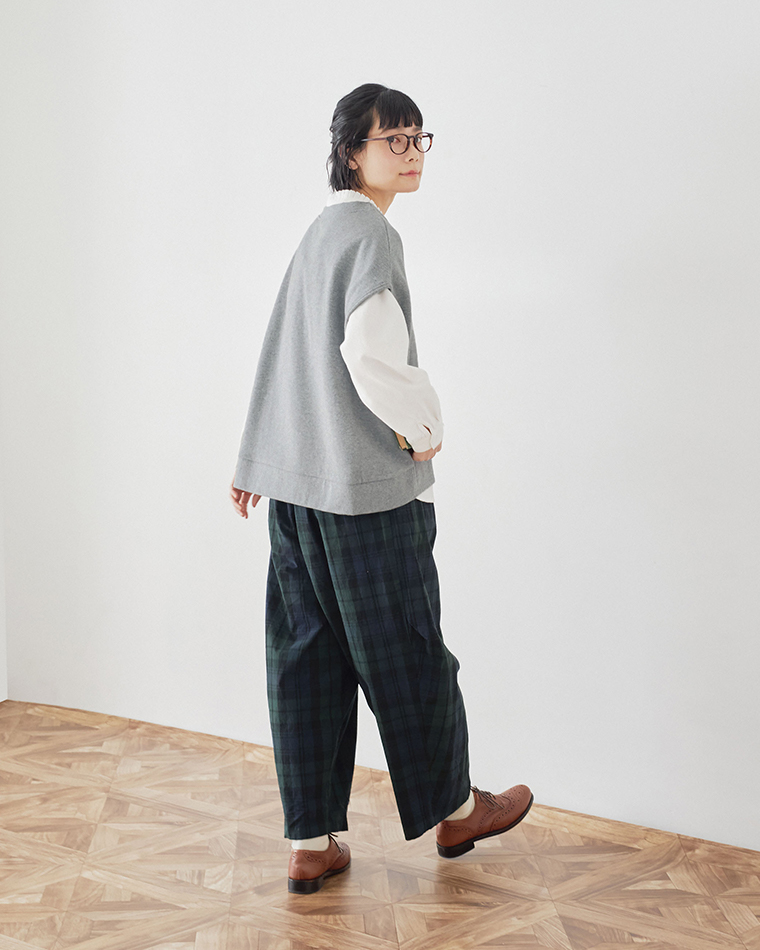 トップグレーの裏毛ベストとチェックパンツの後ろ姿