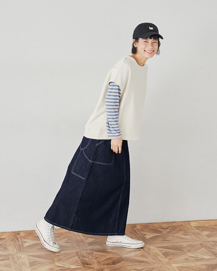 キナリの裏毛ベストとボーダーシャツ、デニムスカートを合わせたコーディネート（前かがみで笑顔のポーズ）