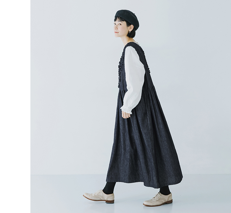 コットンリネンループ染めインディゴ前後フリル使い2wayノースリーブワンピースのインディゴを着たモデルが横向きで歩いている