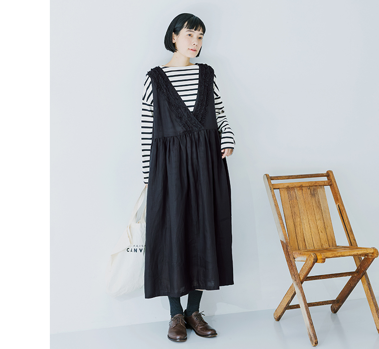 14番手洗いざらしリネン無地前後フリル使い2wayノースリーブワンピースのブラックを着用したモデルがバッグを持って立っている