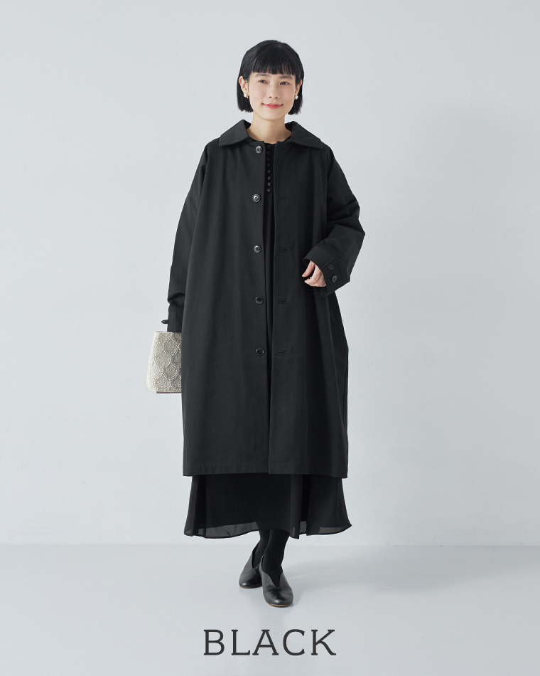 ブラックのロングステンカラーコートを着用した、シンプルで上品なナチュラルコーディネート