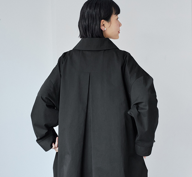 背中にタックを入れたデザインで、後ろ姿もきれいなブラックのロングステンカラーコート