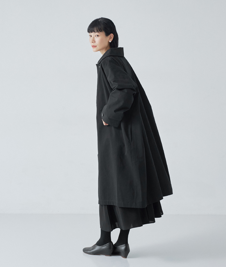横から見てもすっきりとしたシルエットの、ブラックのロングステンカラーコート
