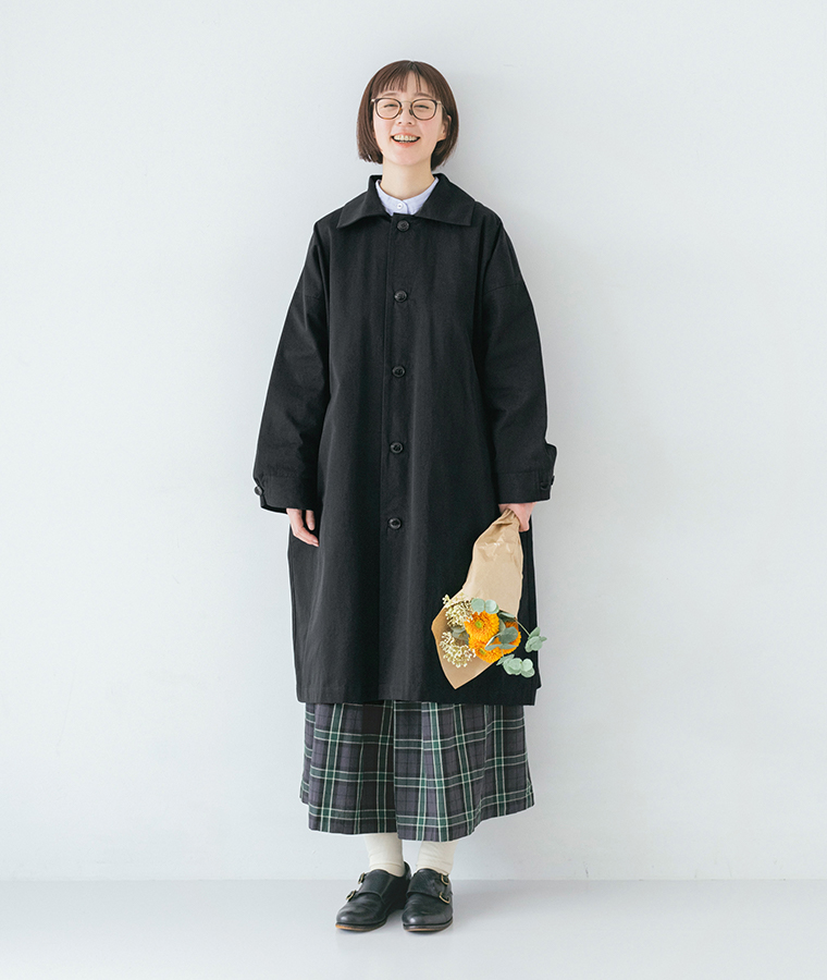 ブラックのロングステンカラーコートを主役にした、チェック柄ボトムとのカジュアルなコーディネート