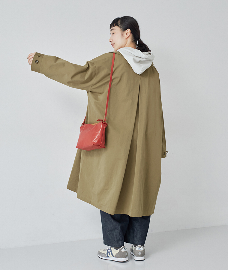 背中にゆとりを持たせたデザインの、ダークベージュのロングステンカラーコート後ろ姿