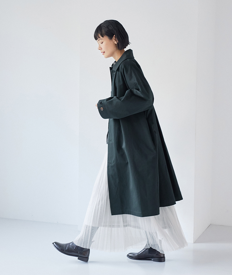 軽やかに揺れるシルエットが印象的な、ネイビーのロングステンカラーコート着用イメージ