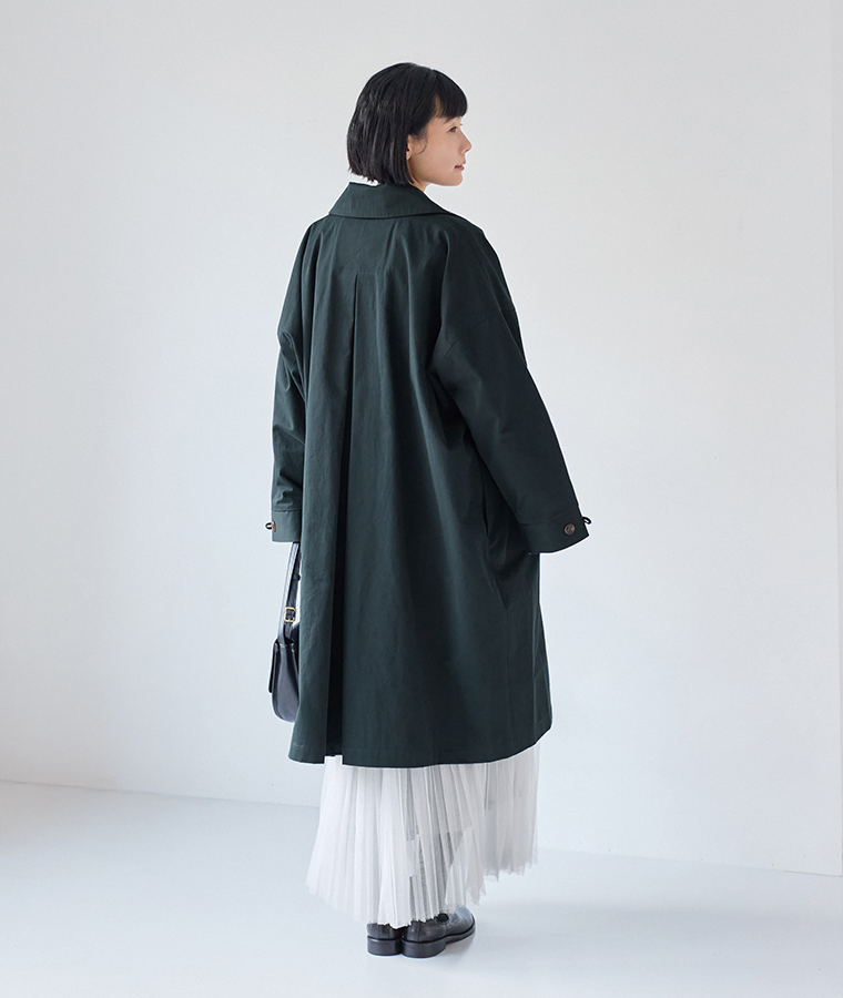 後ろ姿まで美しい、ネイビーのロングステンカラーコートのバックスタイル