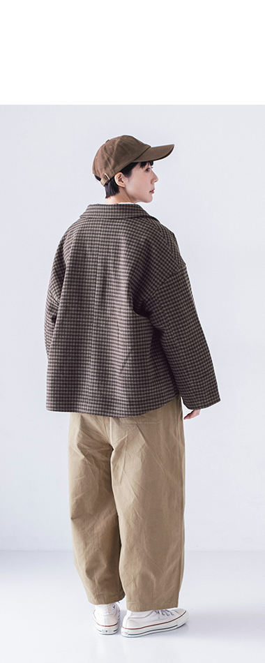 チェックジャケットとベージュパンツの後ろ姿、カジュアルなスタイリング