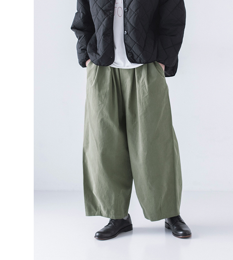 モスグリーンのワイドパンツと白Tシャツを合わせたカジュアルスタイルの下半身アップ
