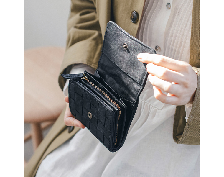 zuccheroのレザーメッシュ三つ折財布を手に持った使用イメージ