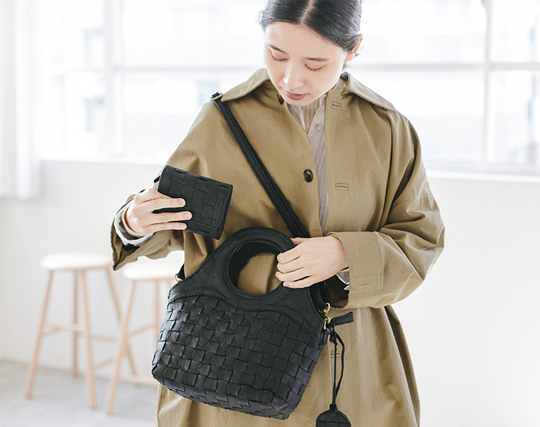 zuccheroのレザーメッシュ繰手2wayトートに三つ折財布を収納しようとしているシーン