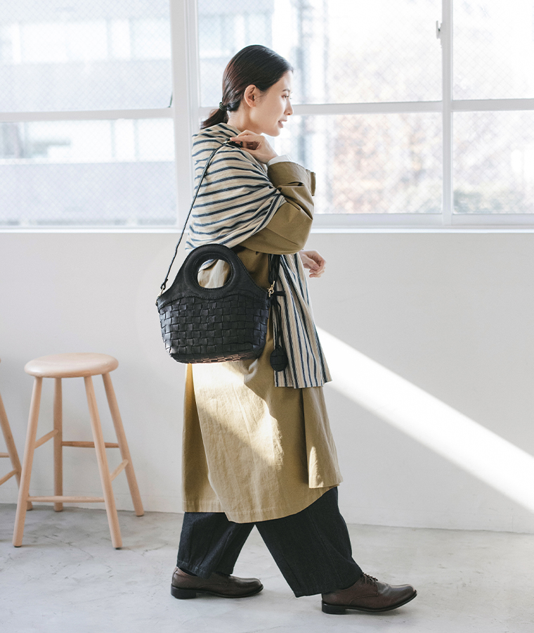 zuccheroのレザーメッシュ繰手2wayトートを斜め掛けした女性モデルの全身スタイル