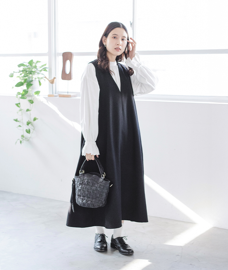 zuccheroのレザーメッシュバケツ型トートを持った女性モデルの全身スタイル