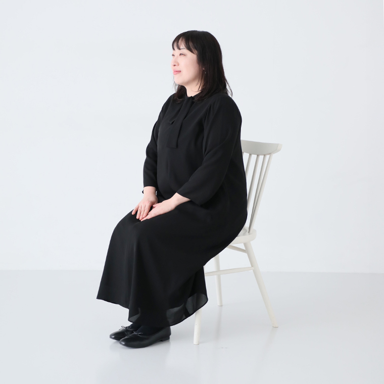ボウタイAラインワンピースLサイズを着たスタッフ（162cm）が椅子に座ったコーディネート