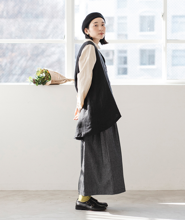 レイヤードしやすいロングベストとブラックワイドパンツの横から見たシルエット