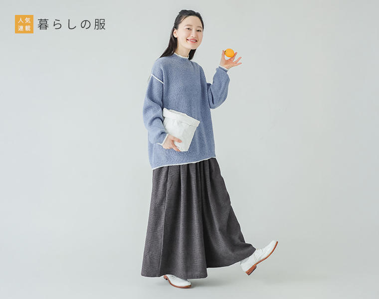 暮らしの服　ネルタックワイドパンツ ブラック×スモークグレーを着用しグレーのニットトップスと白い靴を合わせた全身正面カット