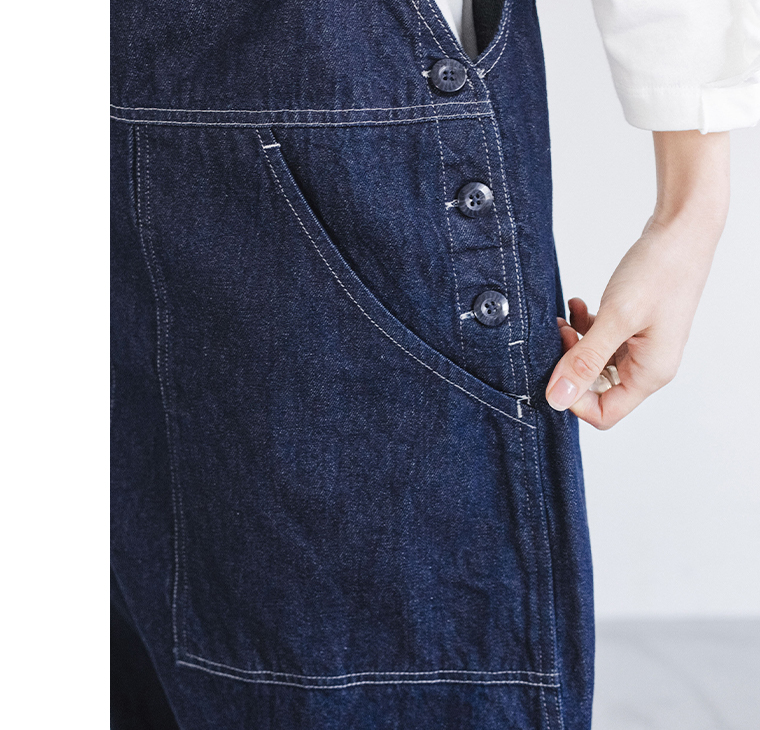 デニムオーバーオールのサイドボタンとポケットのディテール